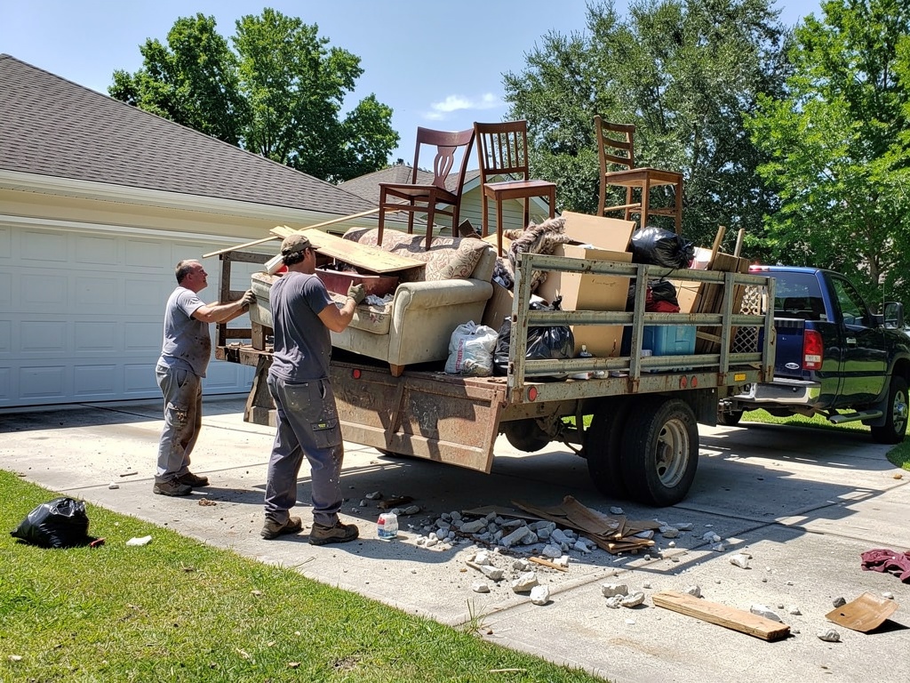 Crew loading junk into trailer for property cleanout in Eastern North Carolina